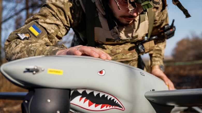 A member of Ukraine's 15th Separate Artillery Reconnaissance Brigade performs a check on a 