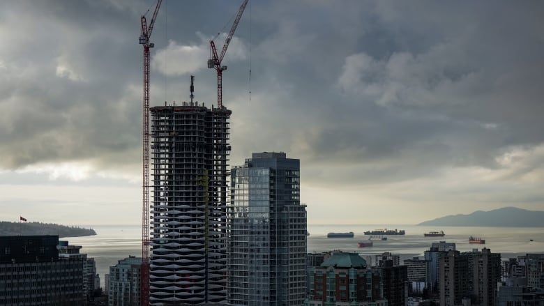 Cranes are seen above a condo tower under construction in downtown Vancouver.