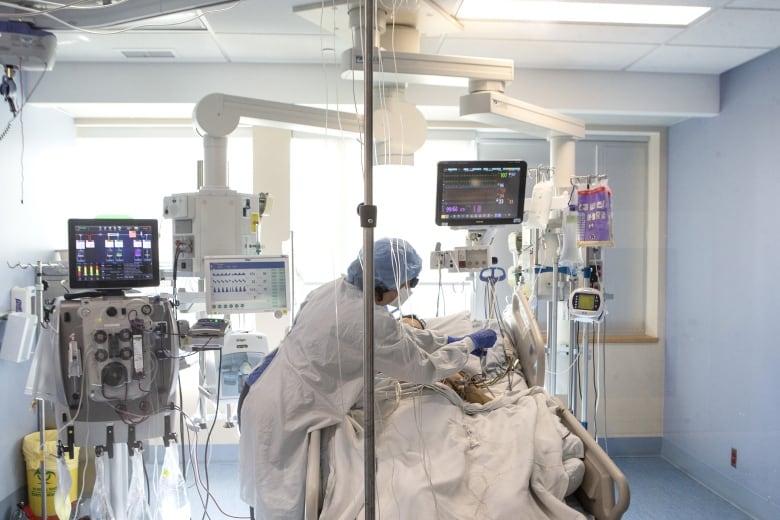 A nurse tends to a patient in hospital. 