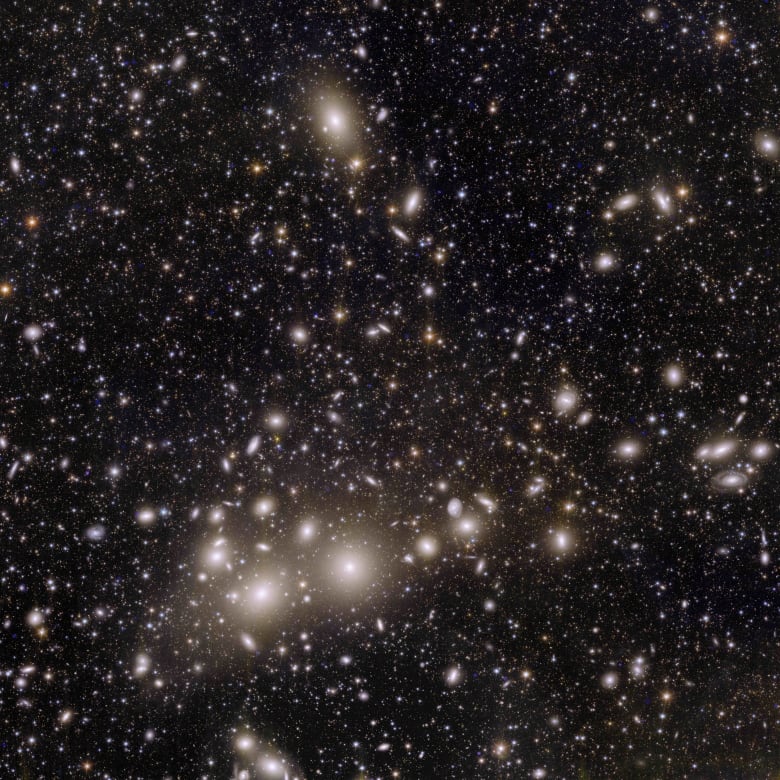 An image shows a multitude of stars and distant galaxies.