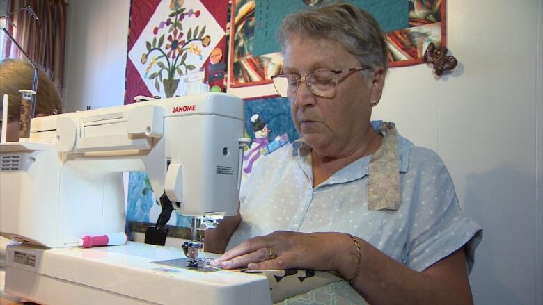 A woman uses a sewing machine 