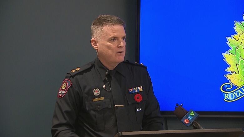 A man in a uniform stands behind a podium. 