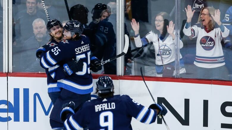 Hockey players celebrate a goal