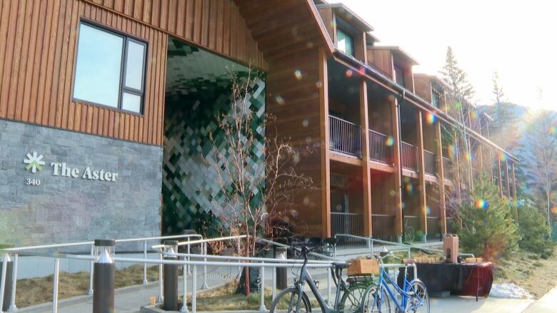 a newly built wood and stone three floor condo building is pictured in Banff