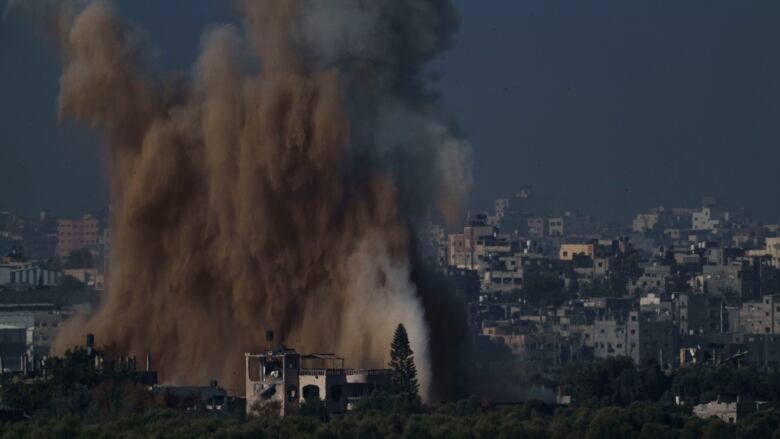 Dirt and debris rise high above a city following an airstrike.