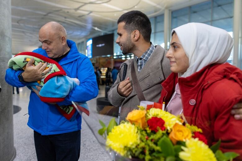 Member of parliament Larry Brock, who helped facilitate the reunion holds baby Sila. Ahmad Abualjedian greeted his wife, Yara, and his daughter, Sila.