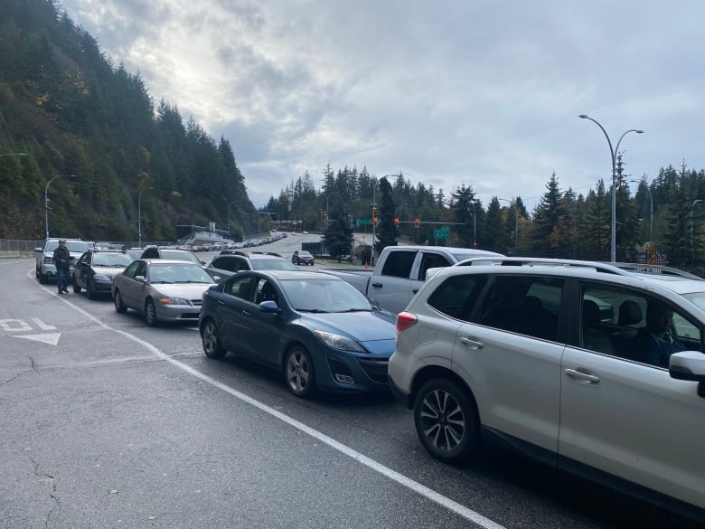 A number of cars lined up on a highway.