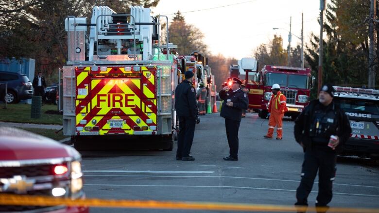 Fire trucks and people on a street.