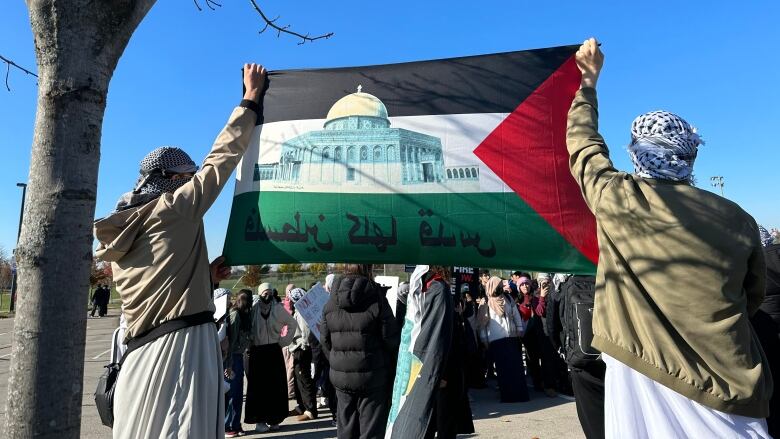 two students hold Palestinian flag