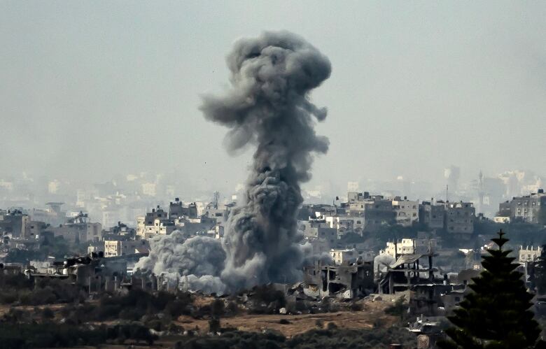 Smokes billows above a destroyed buildings following an airstrike.