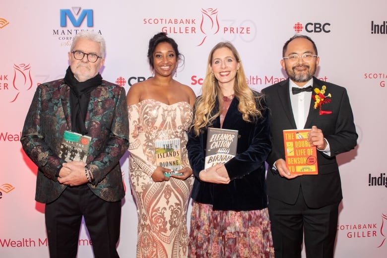 Four nominated writers in formal dress stand on the Scotiabank Giller Prize red carpet holding their books.