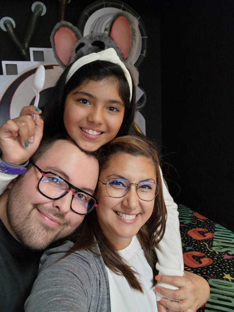 A family hugs inside a Chuck E. Cheese restaurant