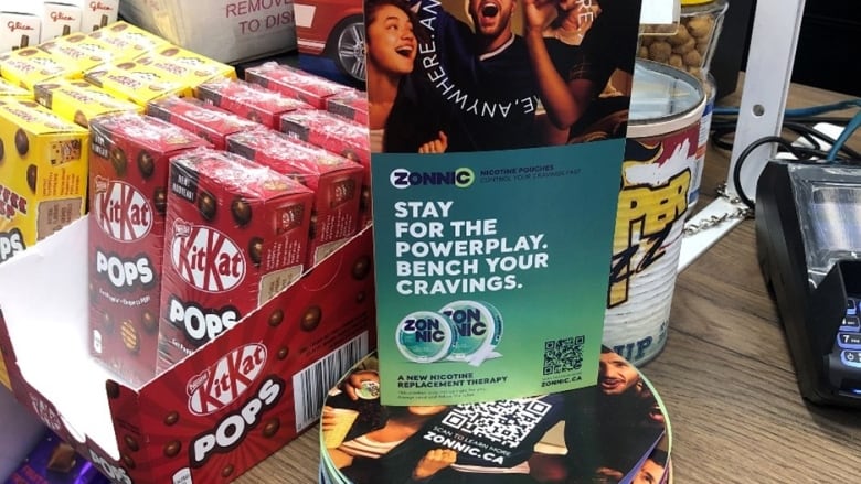 An advertisement for Zonnic, flavoured nicotine pouches, is found on a Canadian convenience store counter next to candy. 