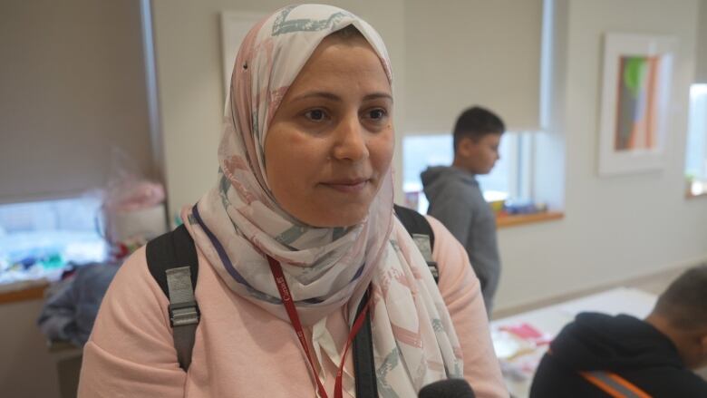 A woman in hijab speaking to a microphone.