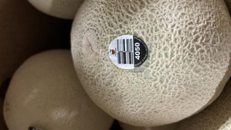 A cantaloupe with a label on it.