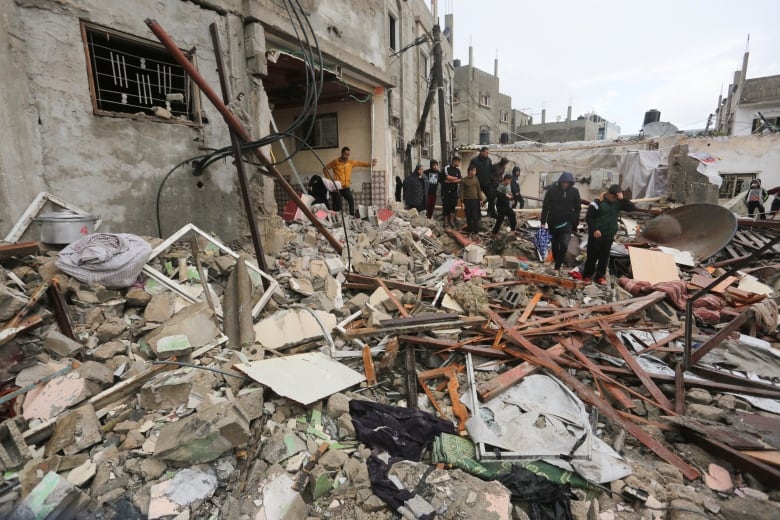 Palestinians look at destruction after Israeli strikes on Rafah, Gaza Strip. 