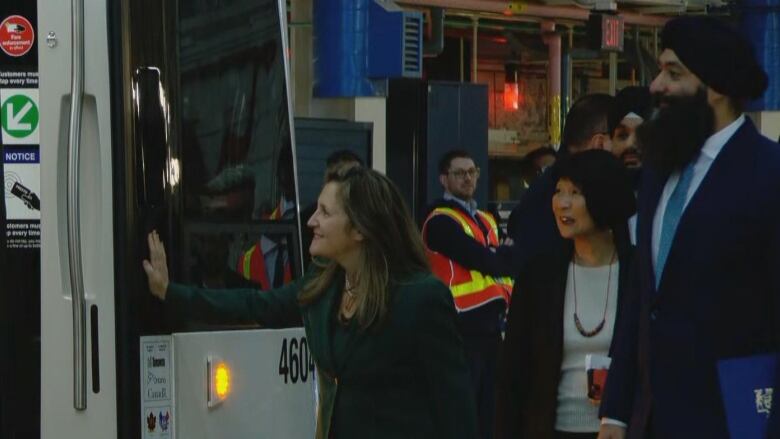 Three people look at a new streetcar. 