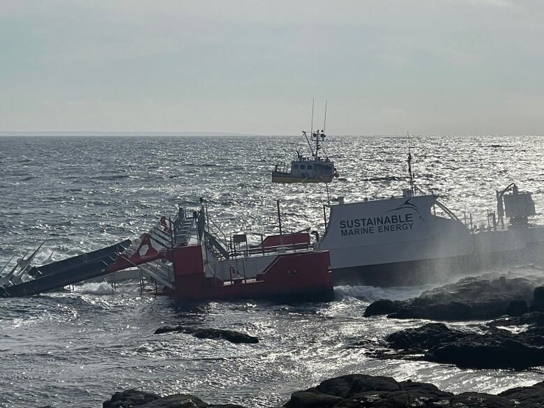 A rope runs from a fishing boat in the distance to the turbine platform which is closer in the frame.