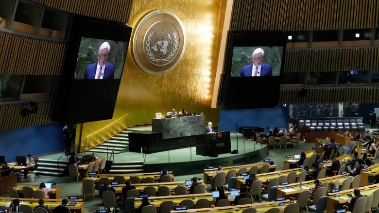 People in a large hall watch a man speak