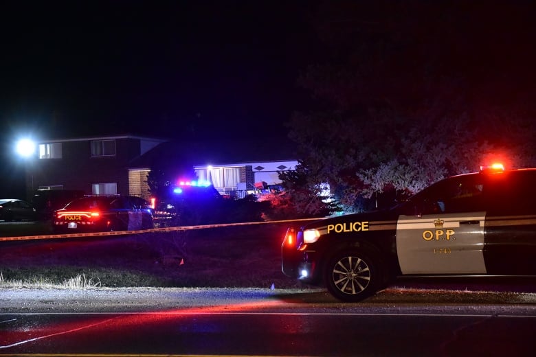 An OPP vehicle sits outside of a home surrounded by caution tape. 