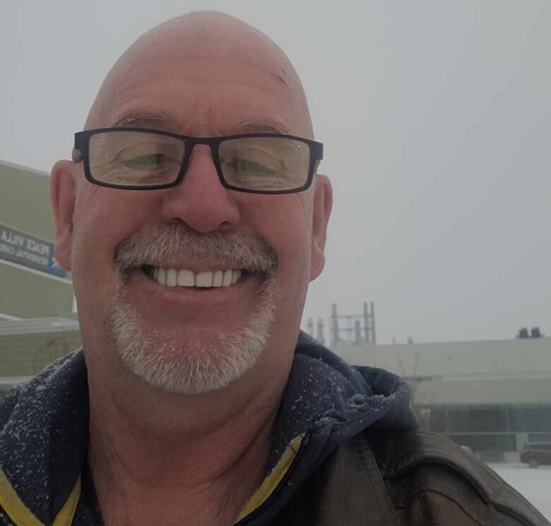 A man standing in front a snowy building