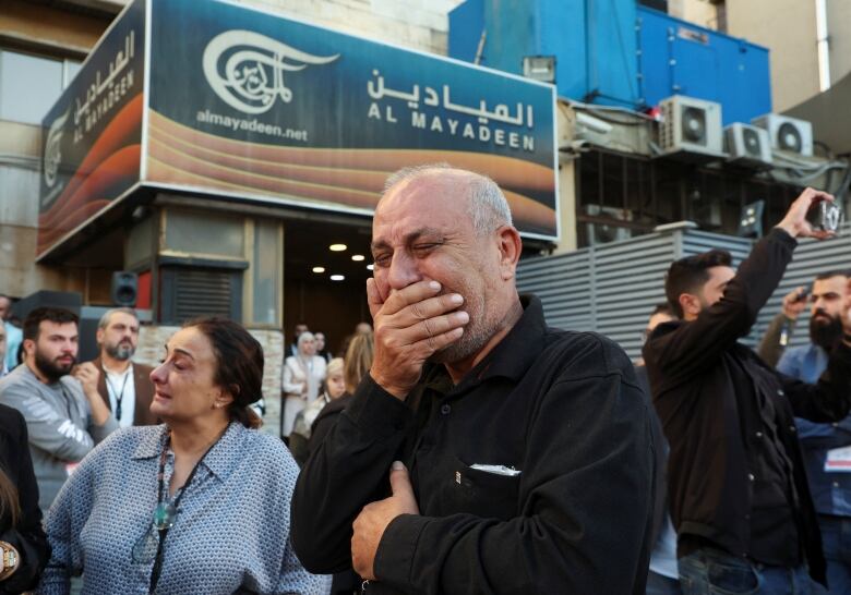 Colleagues of the two journalists of Lebanon-based Al Mayadeen TV channel, who it says were killed by an Israeli strike in southern Lebanon, mourn as they stand outside the channel's building in Beirut, Lebanon November 21, 2023. 