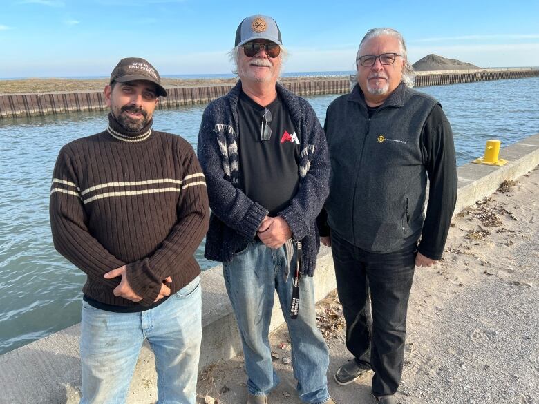 Three men standing on a dock