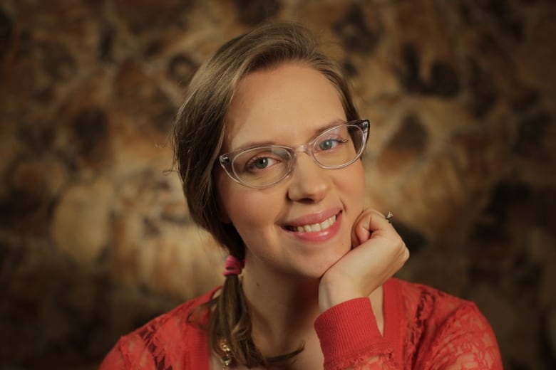 A white woman with brown hair poses for a headshot.