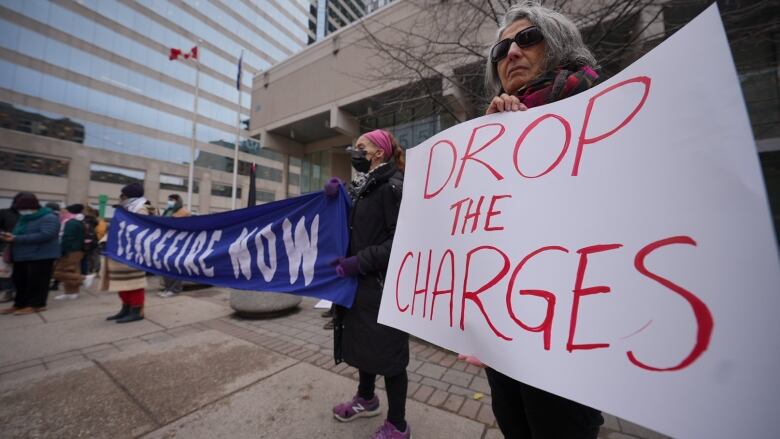 A woman holds a sign that reads 