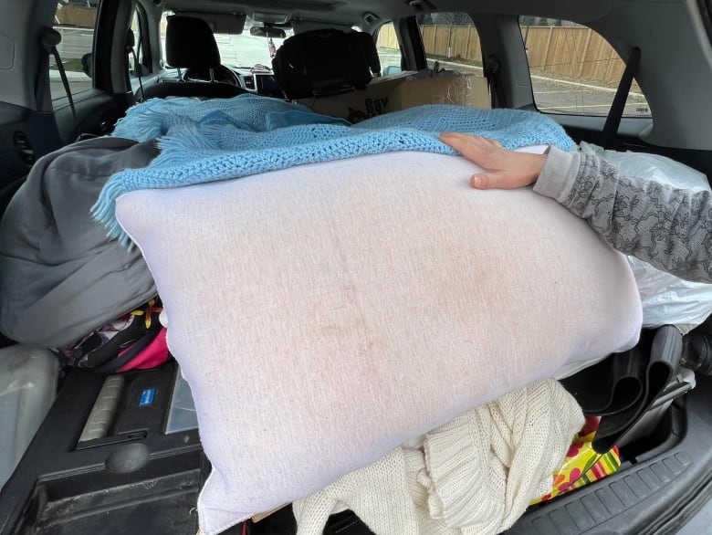 woman holds foam and blankets