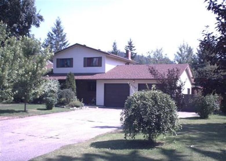 A single family home with a two-car garage and large yard and driveway.