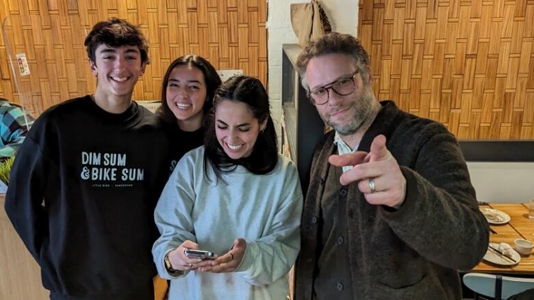 Four people posing for a photo inside a restaurant.