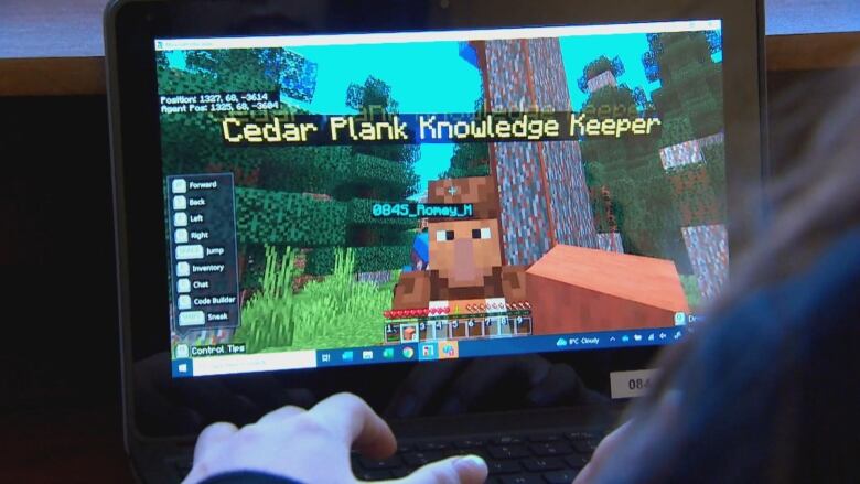 A Minecraft game is played on a screen with the words 