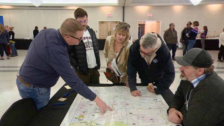 People look over a map of Northern Alberta to see where a proposed pipeline and carbon capture project could be built.