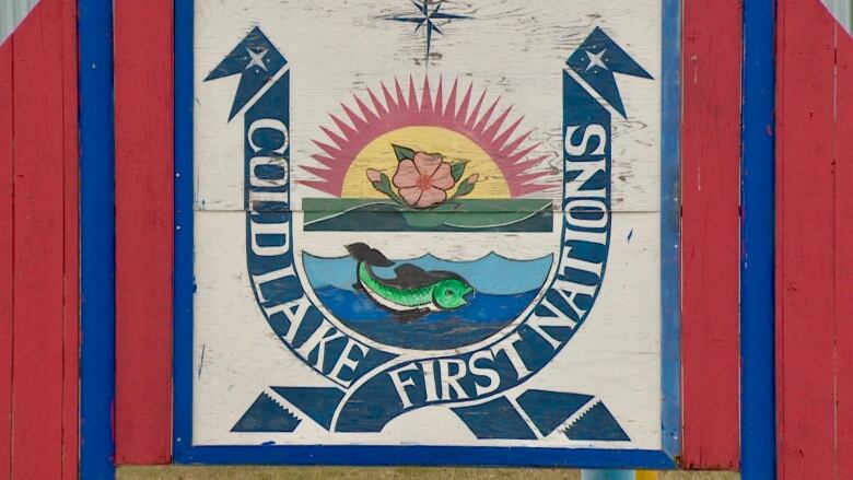 A sign shows the logo of the Cold Lake First Nations, which includes a fish, water, flower and sunrise.