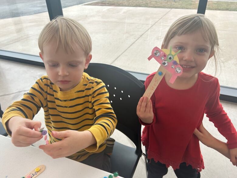 Two young children making crafts. 