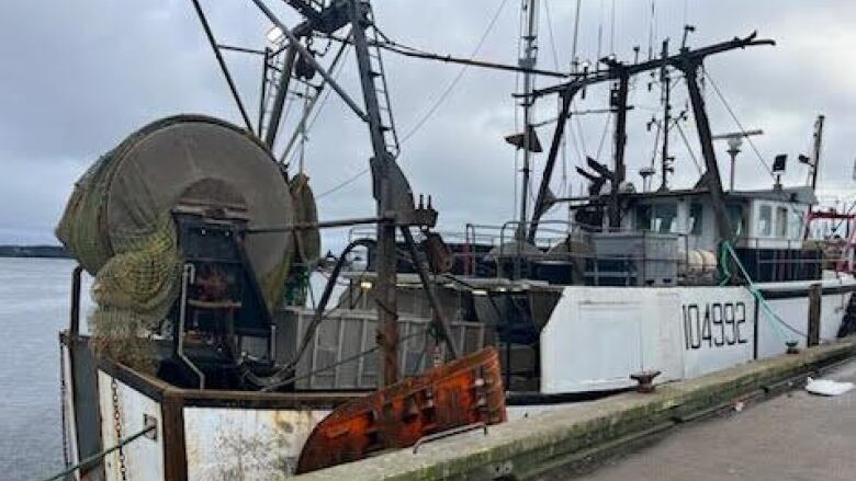 a fishing boat is tied to a wharf 