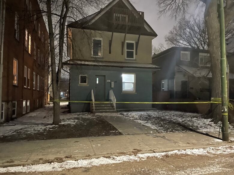 A blue house taped off with police tape