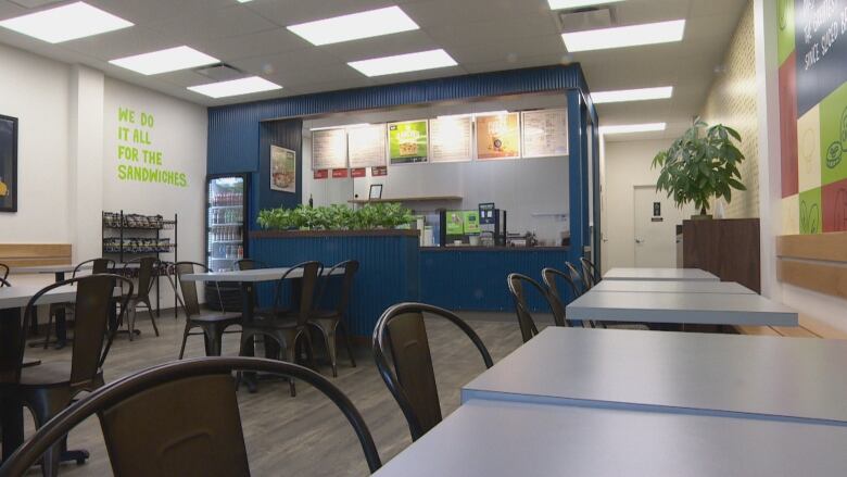 The seating area of a sandwich shop sits empty.