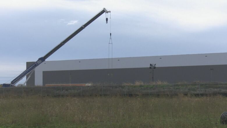 A crane is used during the construction of a large industrial building.