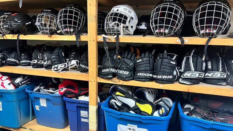 A shelf full of hockey equipment. 