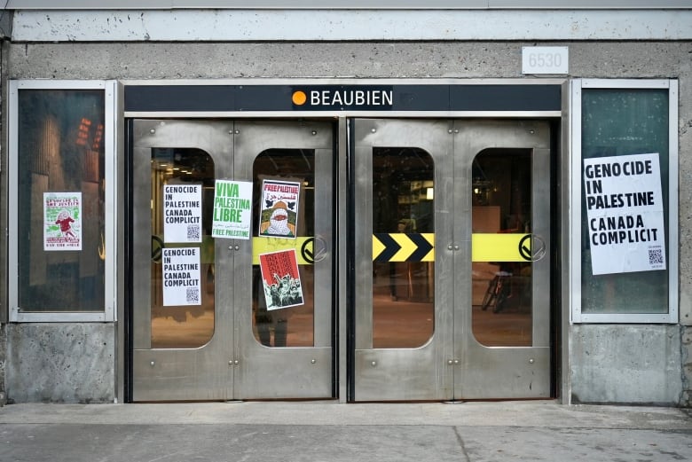 The entrance to a subway is plastered with posters. 