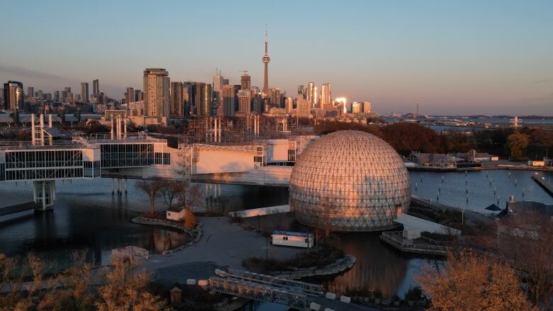 Aerial (drone images) of Ontario Place at sunset on November 15, 2023. Toronto city skyline and Lake Ontario. See Cinesphere dome, pods and city skyline in bg.