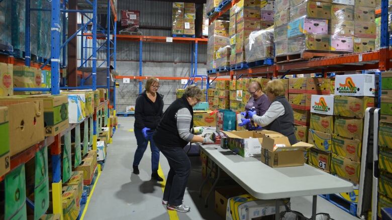 A group of volunteers sort through food donations and put them away in their corresponding place at the Centre de bnvolat et moisson Laval warehouse in Laval, Que. 