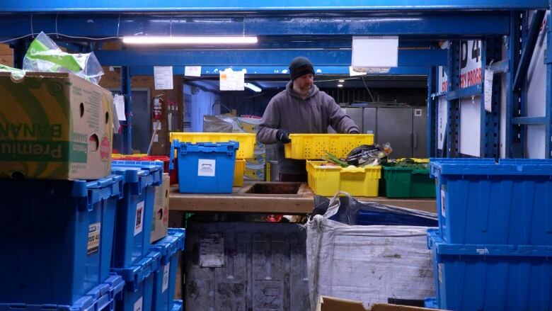 A volunteer at Loaves and Fishes sorts through produce.