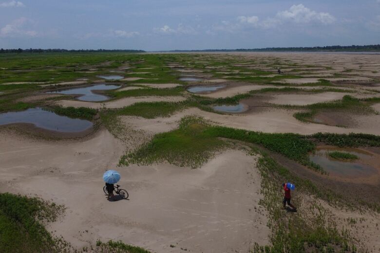 Two people are shown in a rural area in a photograph taken from overhead.