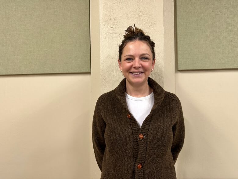 Stacey Bricknell standing in front of a wall at Community Health Caring KW in Kitchener.