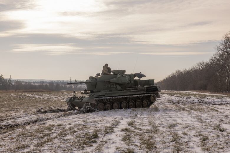 Ukrainian soldiers drive an anti-aircraft-gun tank on near the outskirts of Kyiv.