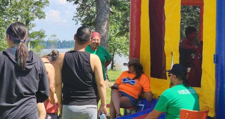 Volunteers stand by a bouncy castle. 