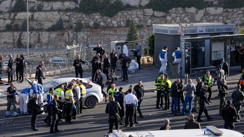 Israeli police officers and members of the Zaka rescue service are seen at the scene of a shooting attack at a Jerusalem bus stop.